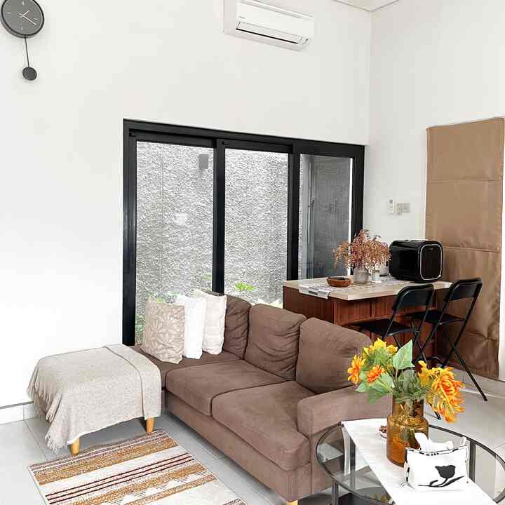 Brown and beige toned living room featuring a brown sofa, round coffee table, and a home cafe setup creating a cozy atmosphere