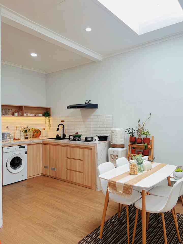 Natural color and wood tone kitchen and dining room featuring a 4-person dining table with simple lighting creating a cozy atmosphere