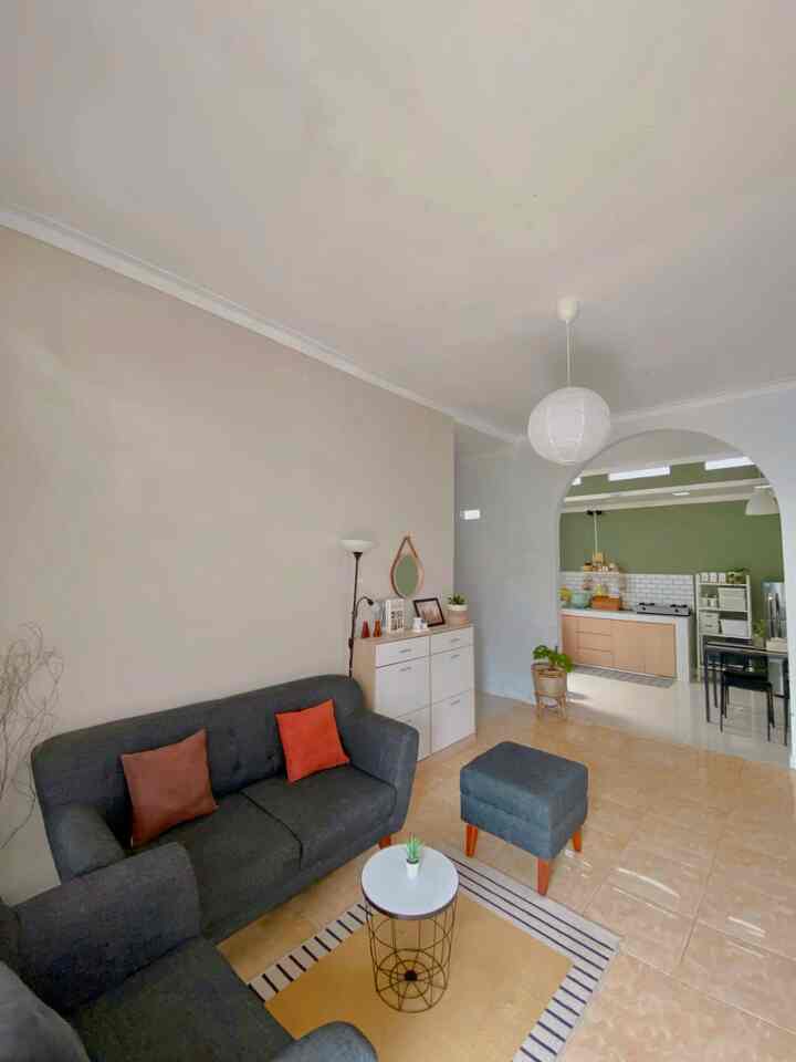 Natural modern small living room featuring gray sofas, white storage cabinet, and an arched doorway to the kitchen