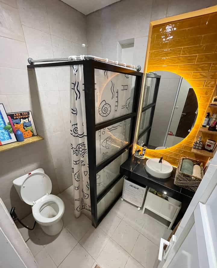 Make over Kamar Mandi standar Developer 2,5m X 1,78m.
.
Standar bawaan developer seringnya kurang sesuai keinginan kita terutama pada materialnya. Sambil menunggu ada budget lebih, kami mendekor sedikit pada dinding wastafel dgn tiles warna honey take / kuning mustard yg glossy agar terkesan lebih segar, Cermin setengah bulat dgn lampu Led, lalu memberi partisi kaca & aluminium utk batas area kering dan basah. Sisanya kita dekor dengan ambalan berbahan plastik daur ulang motif terazo yg estetik dgn edging tumpul, sehingga aman untuk kamar mandi karena bahannya kokoh, tidak tajam dan waterproof. Berguna untuk menaruh poster pajangan, diffuser dan tanaman.
.
Gimana menurut teman-teman cocok ga perubahan kecil utk kamar mandi ini? Komen ya 😉
#RenovasiKamarmandi #BathroomMakeOver #InspirasiKamarMandi #CerminKamarMandi #CerminSetengahBulat #TilesDindingKamarMandi #LightingKamarMandi #AmbalanPlastikDaurUlang #AmbalanKamarMandi #DekorasiKamarMandi 