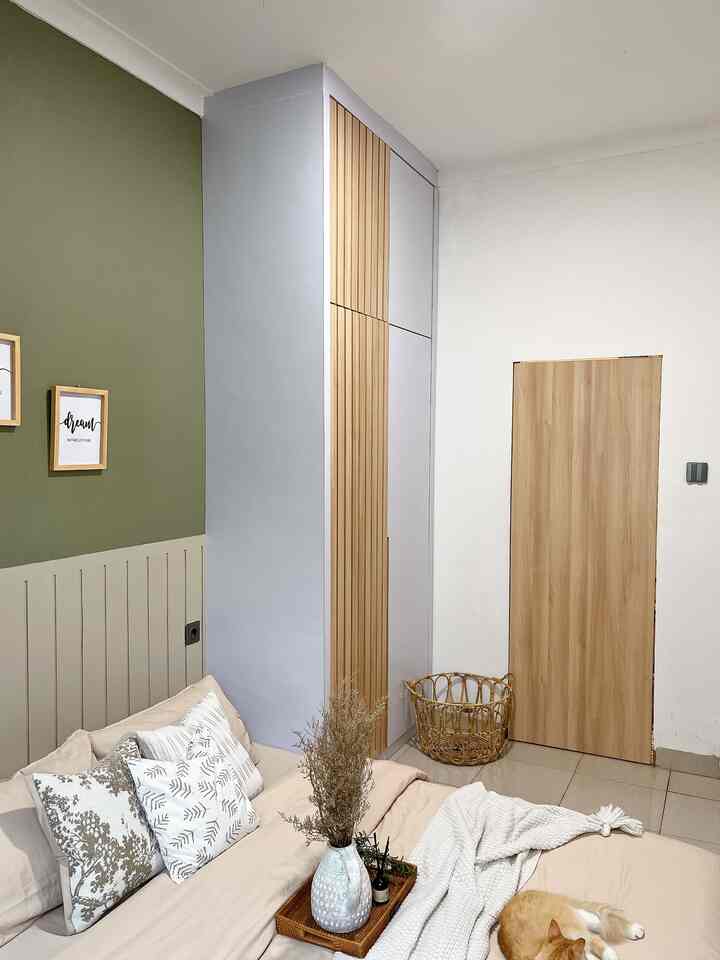 Brown and green toned bedroom featuring wall storage cabinet and a cozy bed with a cat resting, creating a natural atmosphere