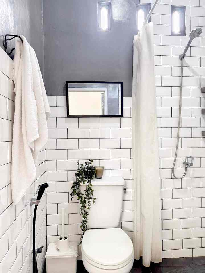 White and gray toned bathroom featuring a toilet and shower in a clean, modern space