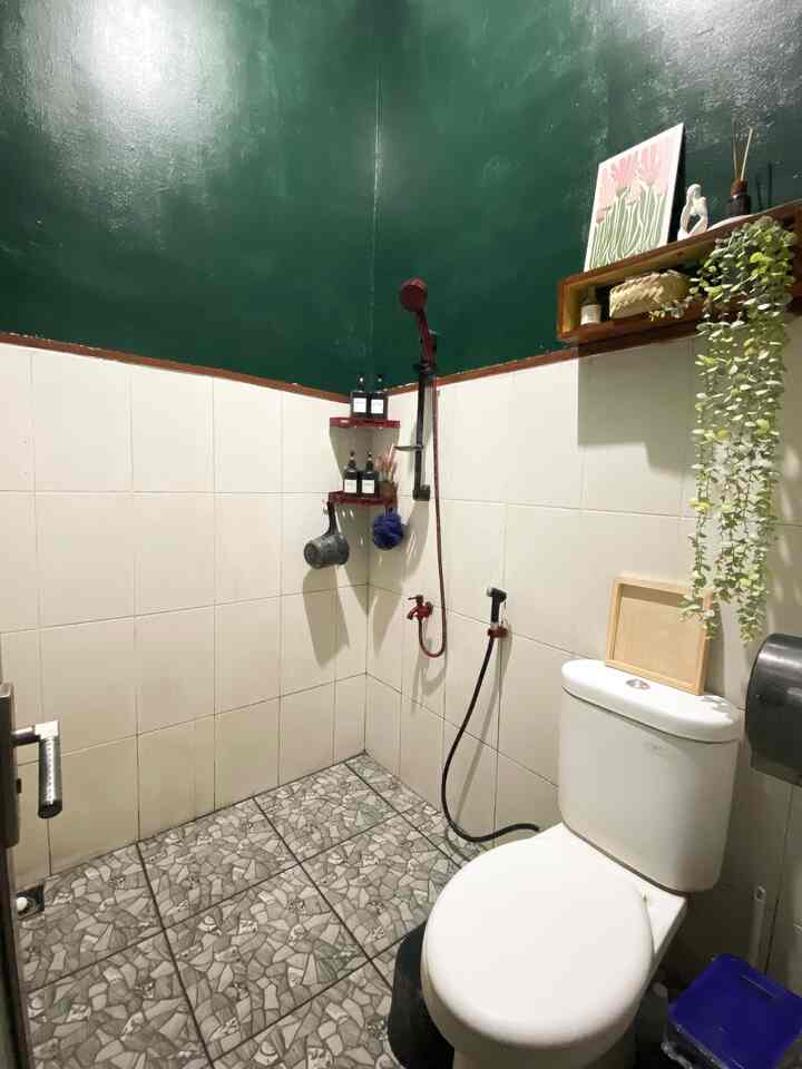 Hallo, everyone🫶🏻
Ini kamar mandi dirumah mizyhm, kamar mandi ini masih bawaan developer.
Tapi sepertinya, keramik lantai ini sudah di ganti oleh pemilik sebelumnya
Karena keramik kamar mandi ini sama persis dengan keramik yang ada di dapur.

Sebenarnya, kami ingin sekali merenovasi kamar mandi mungil ini menjadi lebih compact dengan memindahkan posisi area closet dan menambahkan kabinet wastafel
Hanya saja keterbatasan biaya, karena biaya kami alih fungsikan ke hal2 yang lebih urgent.

Kamar mandi ini sempat di makeover kecil2an sebanyak 2x
Yang pertama, kami pasang stiker anti air bermotif tribal batik nuansa hijau, mengganti kran shower set berwarna hitam dan rak sabun berwarna hitam.
Alhamdulillah setelah pemakaian 2 tahun lebih pun stiker ini masih awet dan menempel.

Makeover yang ke 2, kami cat bagian tembok atasnya dengan warna hijau dan melepas stiker agar tidak terlalu rame. 

Jadi kesan kamar mandinya tetap clean dan adem.
Dengan perpaduan hijau dan putih dengan list coklat. 
Serta penambahan warna merah maroon dan hitam untuk aksesorisnya.
Kami juga menambahakan sedikit hiasan dinding supaya tidak terlalu polos.

Alhamdulillah kamar mandi mungil ini lebih terlihat rapi dan cozy menurut kami dari sebelumnya 🫶🏻✨

Menurut Tetangga Online bagaimana? 🫶🏻

#RenovasiKamarMandi #BathroomMakeOver #InspirasiKamarMandi #CatKamarMandi #WarnaKamarMandi #KamarMandiMinimalis #WallpaperAntiAir #stikerkamarmandi 