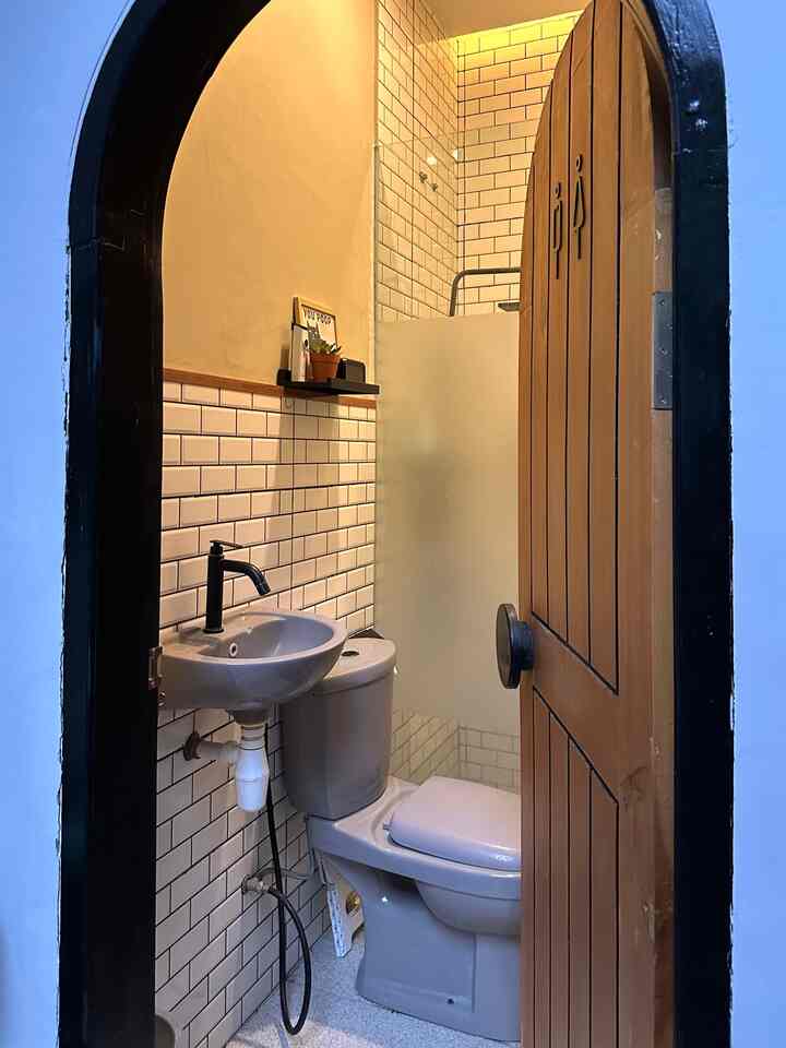 Kamar mandi dengan pintu arch 🚪💫
—
Kamar mandi ini berukuran kecil dengan pintu berdesain arch ala kafe berwarna coklat kayu. Terdapat area basah dan kering yang dibatasi dengan partisi kaca.

Kami menggunakan closet dan wastafel berwarna abu-abu, serta dekorasi lain berwarna hitam, seperti keran air, shower, tempat tisu, dan ambalan.

Untuk sirkulasi udara, kami membuat ventilasi dan menambahkan exhaust pada plafon kamar mandi.

#pintukamarmandi
#keramikkamarmandi
#keramikbata
#wastafel 
#partisikaca
#RenovasiKamarMandi
#BathroomMakeOver
#InspirasiKamarMandi