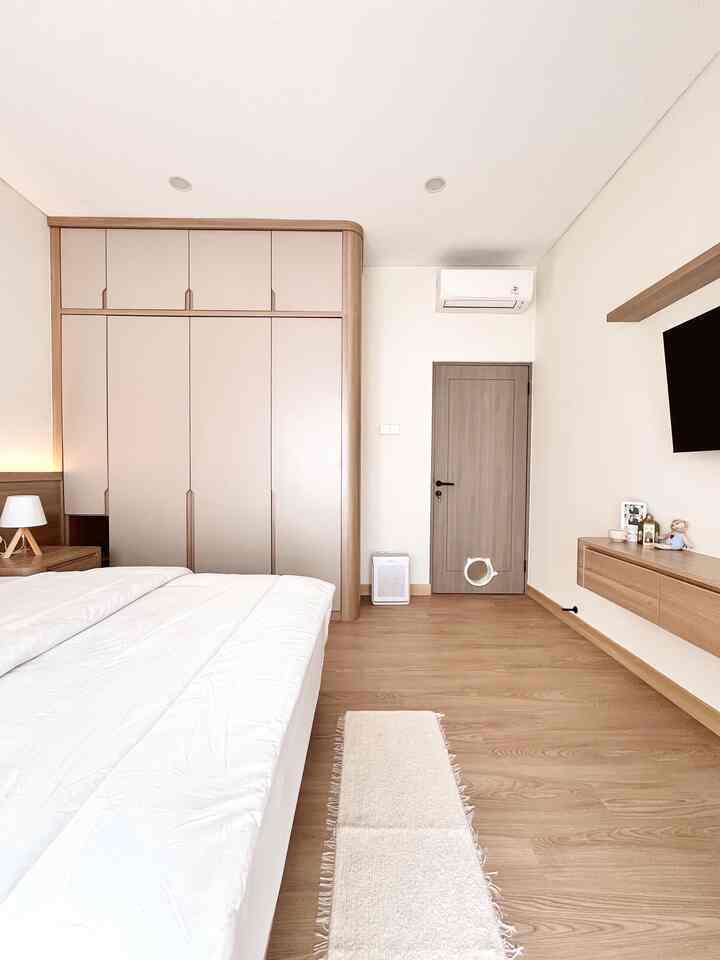 White and wood-toned bedroom for a 4-person household featuring a cat flap door with a hotel-like atmosphere