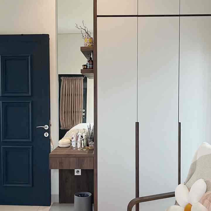 Modern entrance space with white and wood tones, featuring built-in closet and vanity in a clean interior