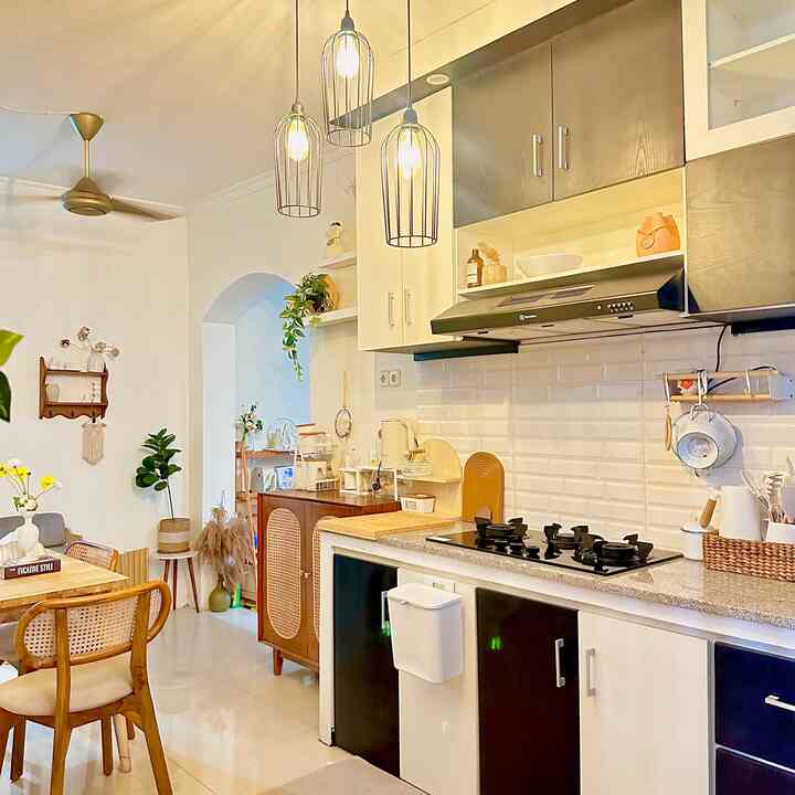 Bright white and brown toned compact kitchen and dining room featuring wood dining table and chairs in a clean, natural setting