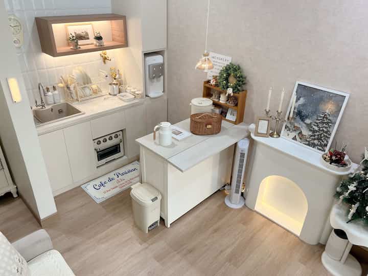 Ivory kitchen island and light brown floor define a compact open space kitchen and dining area