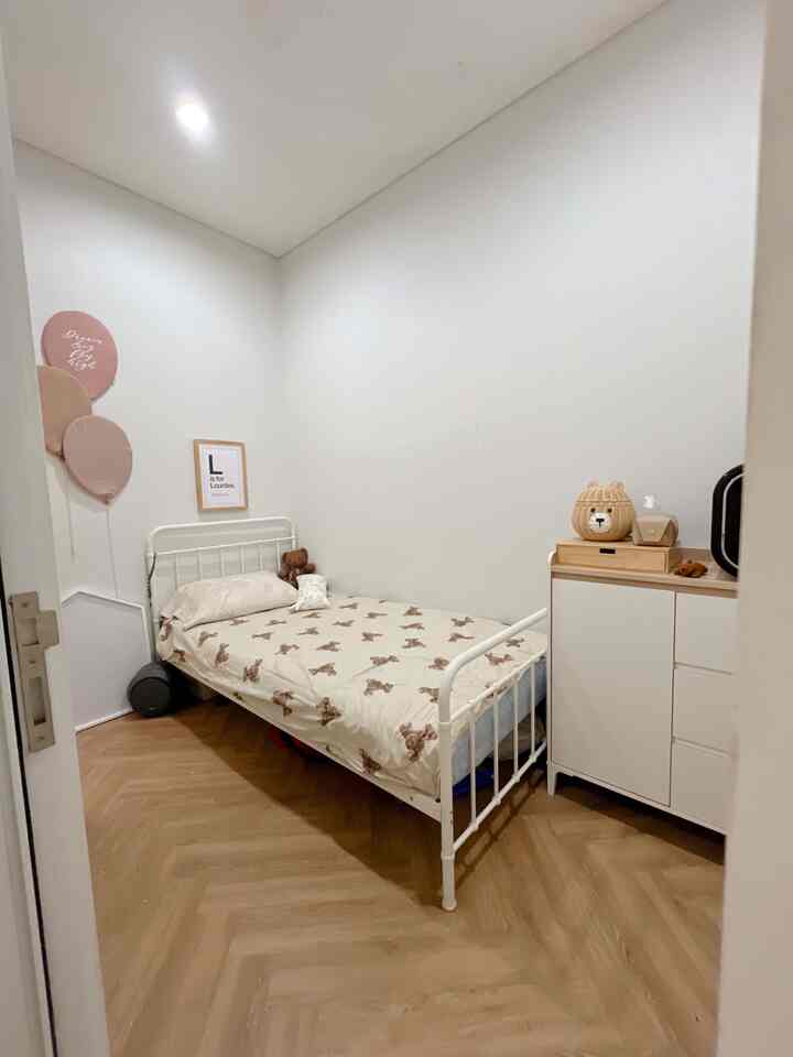Natural and white toned kids' room featuring bear print bedding and a safe curved bed frame in a cozy space