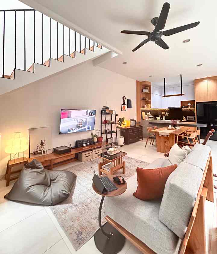 Bright and cozy living and dining room featuring natural brown wood tones and white backgrounds, with comfortable sofa and bean bag seating