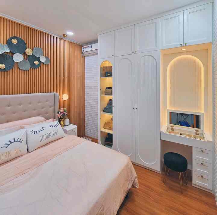 A white and brown bedroom featuring a large built-in storage unit, creating a cozy and organized atmosphere