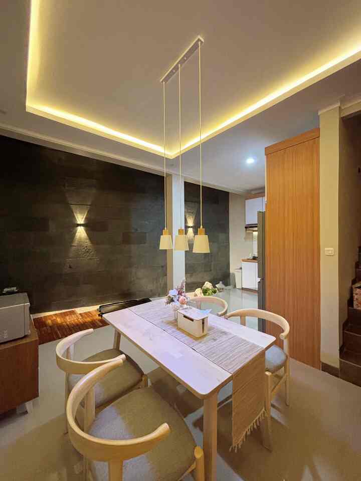 Wood tone and white dining room featuring pendant lights and simple natural decor with a cozy atmosphere