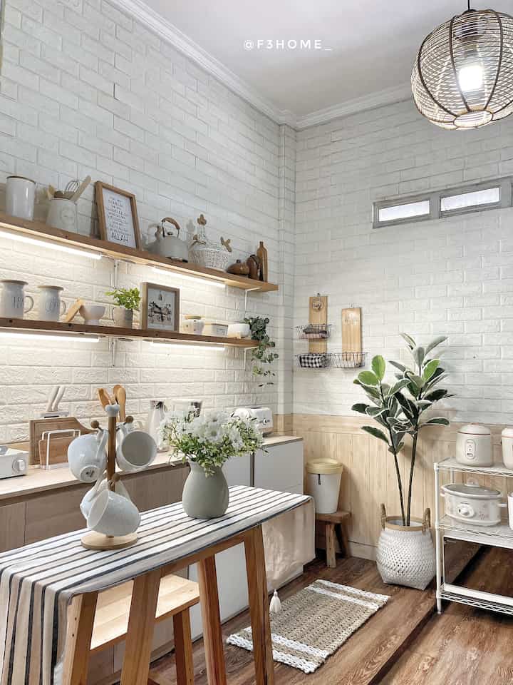 Natural toned kitchen space featuring wooden furniture, plants, and a striped table runner creating a cozy atmosphere