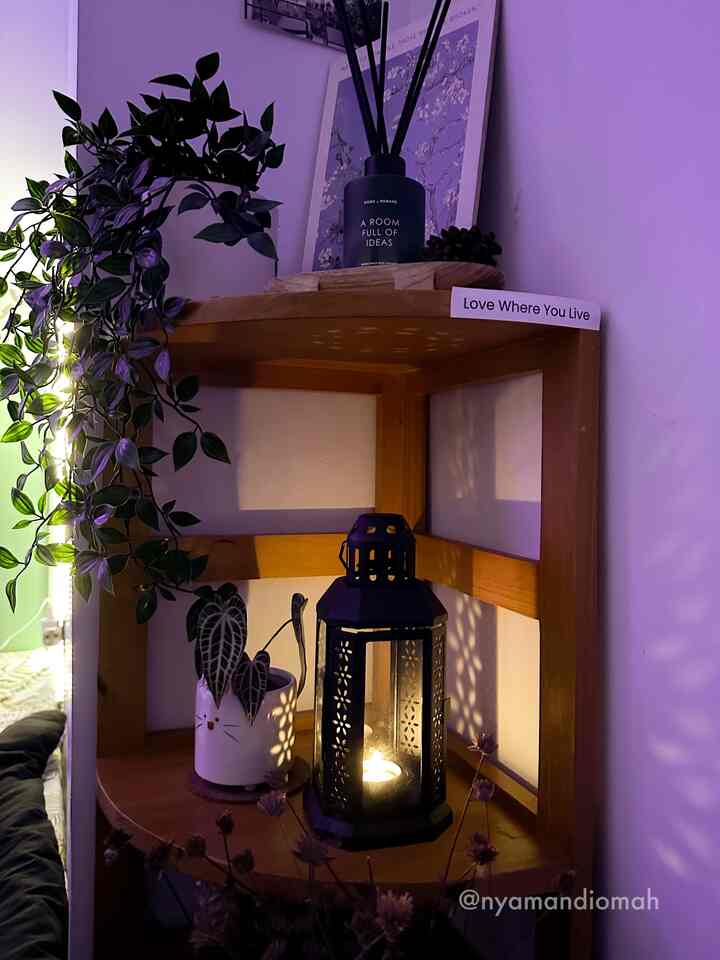 Cozy corner shelf in warm wood tones with purple mood lighting featuring a candle lantern and diffuser