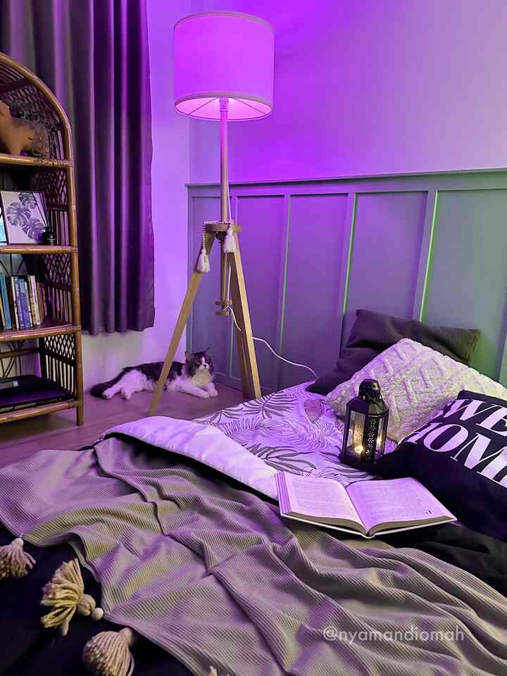 Lavender-lit bedroom featuring a wooden floor lamp and rattan bookshelf creating a cozy atmosphere