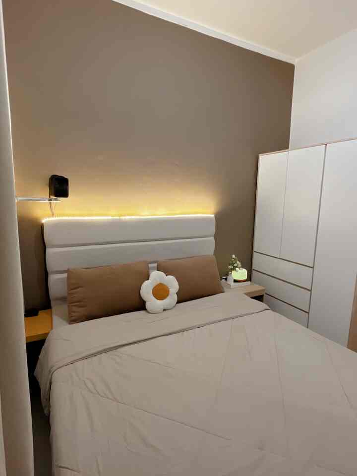 Cozy bedroom with brown accent wall and white furniture, featuring a large bed and nightstands centrally placed