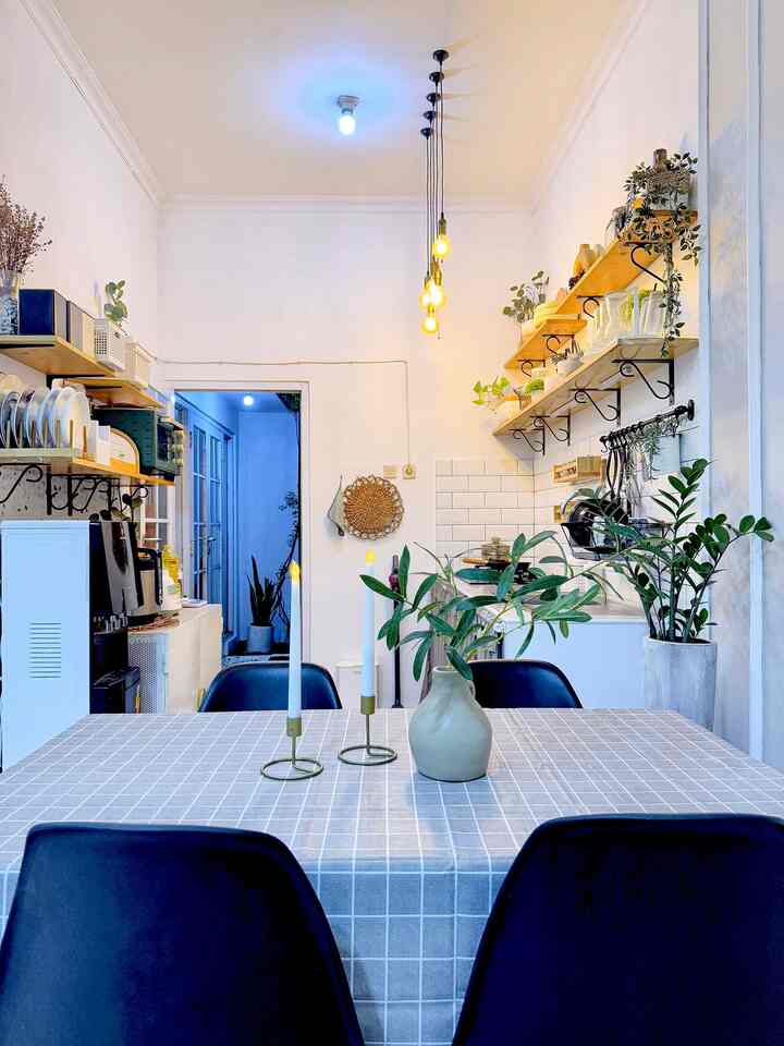 White and blue toned dining room featuring a dining table with chairs, plants, and pendant lights creating a cozy atmosphere