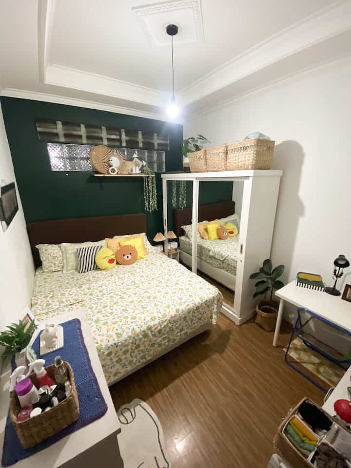 Cara Membuat Kamar Utama uk 3.5 x 2.8 meter Nyaman dan Compact🛌✨💡

Punya kamar dengan ukuran terbatas bukan berarti harus mengorbankan kenyamanan. Kamar ini adalah contoh bagaimana ruang kecil bisa terasa lapang, fungsional, dan tetap estetik🛌✨

Berikut beberapa ide yang bisa di terapkan:
1. Manfaatkan Setiap Sudut dengan Efisien

🗄️Kami memilih lemari dengan pintu kaca geser, yang nggak cuma hemat tempat tapi juga memberi efek visual agar ruangan terasa lebih luas.

2. Warna dan Dekorasi yang Menenangkan

▫️🌲Dinding putih dipadukan dengan aksen hijau gelap menciptakan kesan tenang, hangat, dan modern. 
Tambahan dekorasi dari rotan dan tanaman hijau memberi nuansa alami yang bikin suasana makin homey🪵🍃

3. Penyimpanan Tersembunyi dan Terbuka

🗃️Setiap sudut di kamar ini kami manfaatkan sebaik mungkin. 
Penggunaan kotak anyaman di atas lemari adalah solusi cerdas untuk penyimpanan tambahan tanpa mengorbankan estetika, sementara rak kecil di bawah meja kerja membantu menjaga barang tetap teratur dan mudah dijangkau.

4. Pencahayaan yang Fungsional

💡Lampu gantung simpel jadi sumber pencahayaan utama, sementara lampu meja di area kerja menambah suasana cozy saat malam hari. Pencahayaan yang tepat bisa membuat kamar kecil terasa lebih luas✨

5. Area Kerja Minimalis

🪑Meja kecil yang digunakan cukup untuk kebutuhan kerja ringan. Kursi lipat transparan dipilih supaya tidak membuat ruangan terasa penuh, tapi tetap nyaman digunakan kapan saja.

6. Cermin Besar untuk Efek Visual

🪞🗄️Lemari dengan pintu cermin ini bukan hanya untuk berdandan, tapi juga memantulkan cahaya dan membuat kamar terasa dua kali lebih luas💫

7. Sentuhan Personal yang Membuat Lebih Hidup

🎆🧑‍🧑‍🧒‍🧒Beberapa dekorasi seperti foto pribadi, poster kecil, dan aksesori sederhana kami pajang supaya kamar terasa lebih personal. Dengan begitu, suasananya jadi lebih hangat dan bikin betah🫶🏻

Jadi, inilah cara kami membuat kamar mungil ini tetap nyaman dan compact. Kuncinya ada di penataan yang efisien, pemilihan warna yang tepat, dan sentuhan personal yang bikin setiap sudut ruangan terasa spesial. Semoga ide-ide ini bisa menginspirasi kamu juga!💫💞

#BedroomStyling #InspirasiKamar #KamarTidurNyaman #Lemari #WarnaCatKamar #Lampu #MejaKerja #KamarTidurMinimalis 