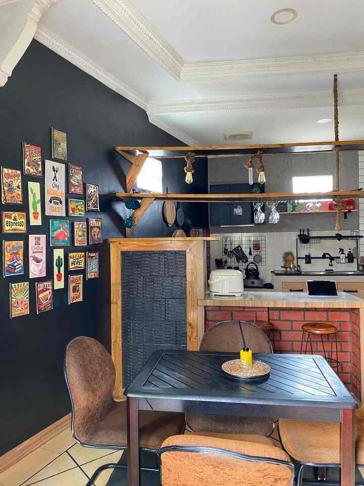 Black and brown toned kitchen and dining area featuring cafe-style wall decor and pendant lighting in a cozy home cafe interior