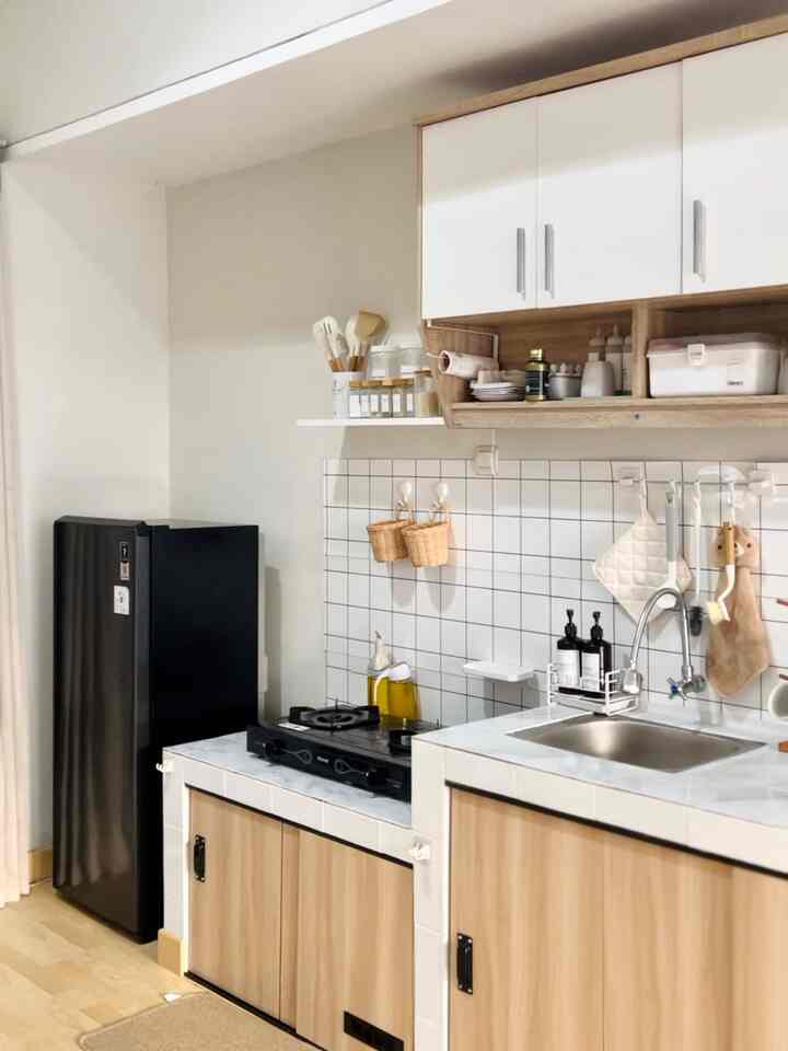 Natural color and black-themed kitchen space featuring a neat sink area and stove with practical, organized design
