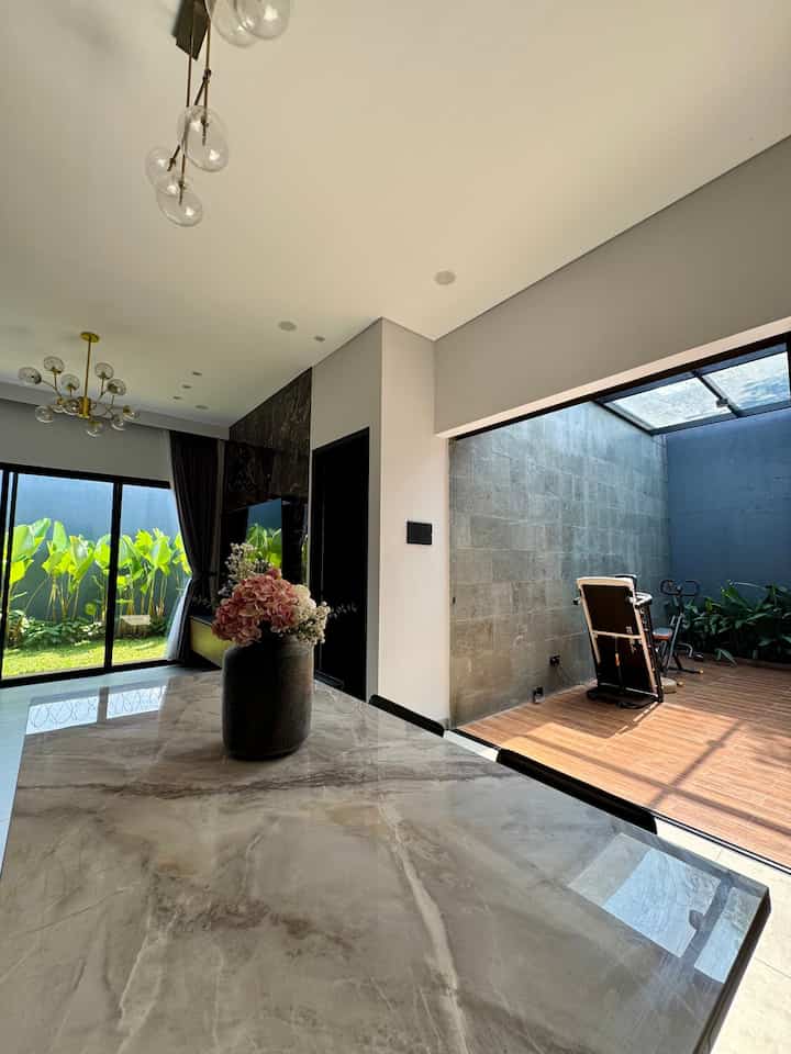 Natural-toned living room and balcony space featuring a marble dining table with bright natural light creating a comfortable interior