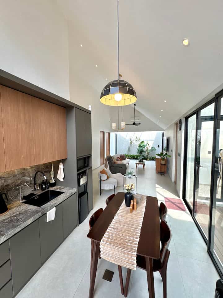 White and wood tone dining and living room with slanted ceiling, featuring modern and natural style elements