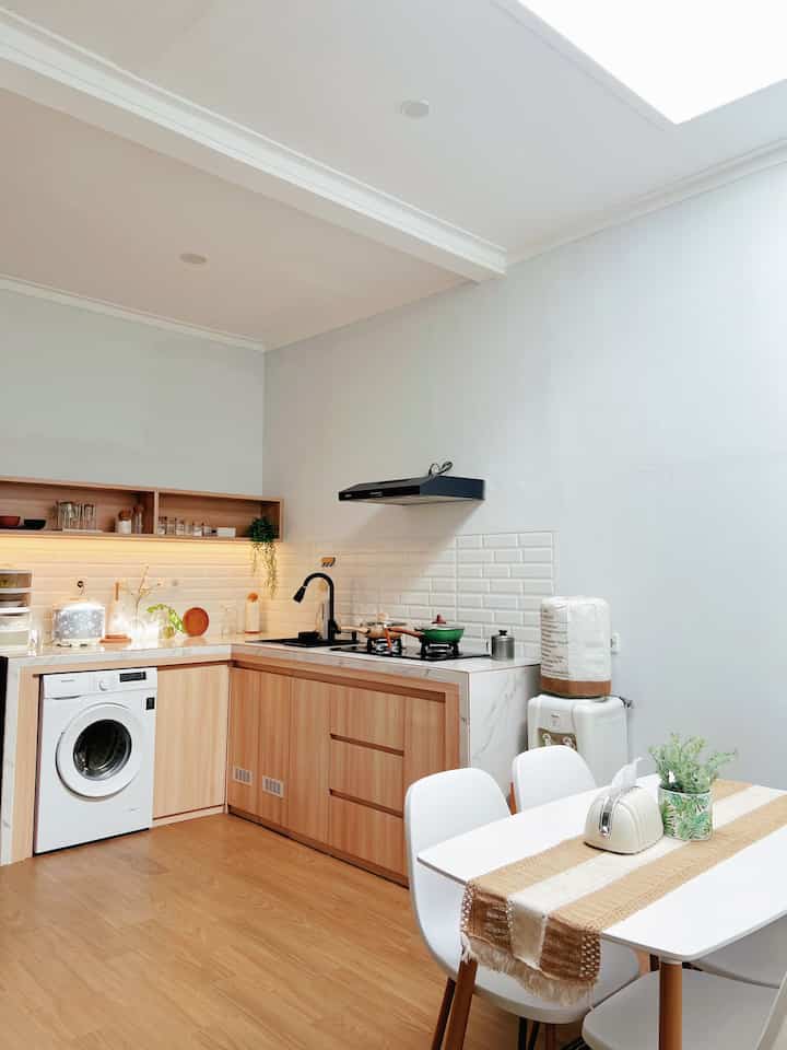 Natural wood tone and white compact kitchen and dining room featuring an open plan layout