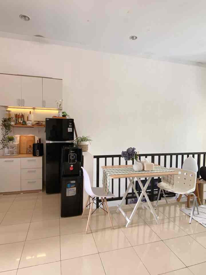 A white and brown dining room and kitchen featuring a dining table with table runner and chairs, creating a clean natural space
