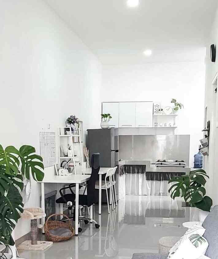 Bright white and gray long narrow kitchen and dining room featuring desk and chairs in a clean open layout