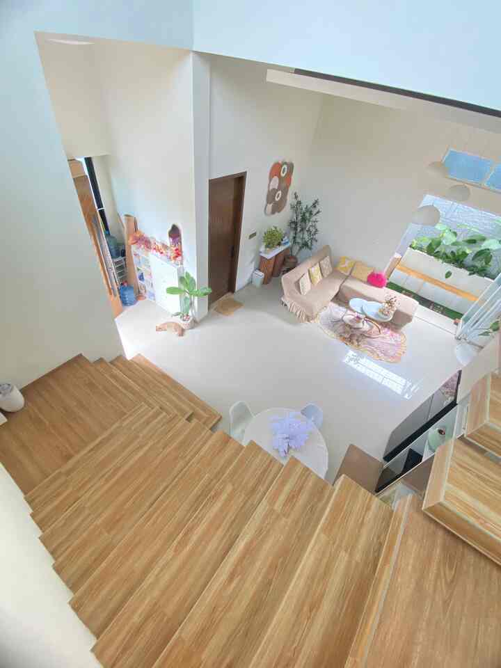 Bright living room with white and wood tones featuring a sofa bed and coffee tables creating a cozy atmosphere