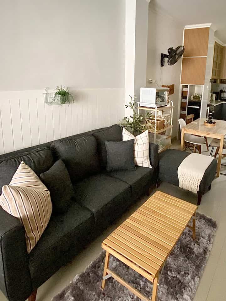 Gray and light brown toned living room featuring sofa and wooden coffee table with natural modern elements