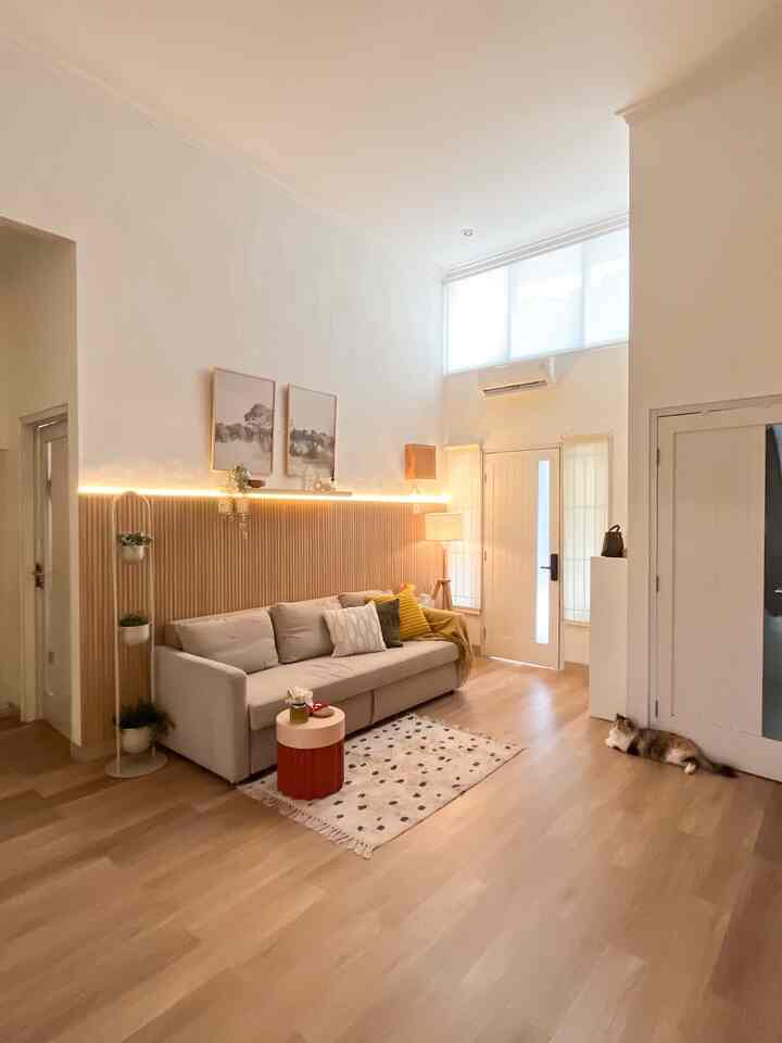 Beige and white toned living room featuring a sofa bed and wooden paneling with a cozy atmosphere