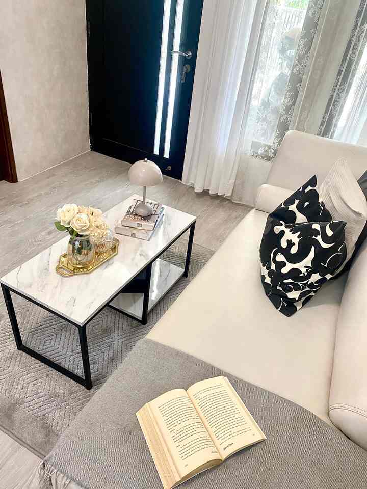 Natural-toned living room featuring a white sofa and marble coffee table, ideal for reading in a simple modern setting
