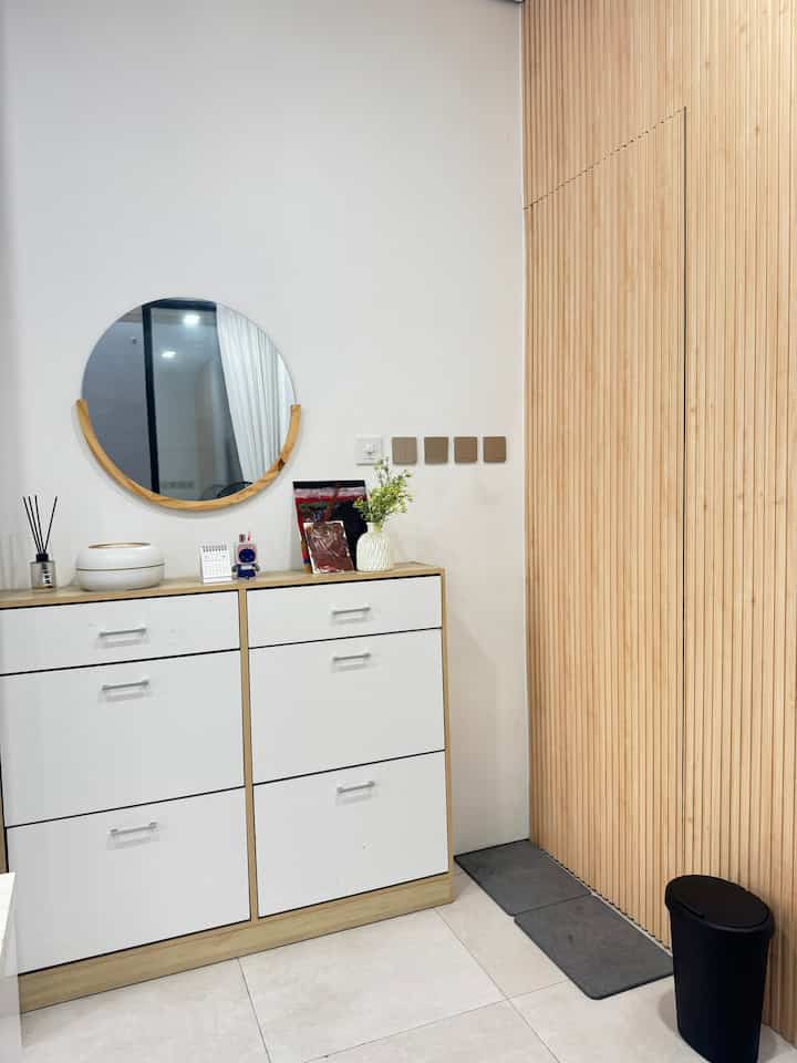 White and wood-tone entrance space featuring a simple shoe cabinet with storage ideas, creating a cozy and organized atmosphere
