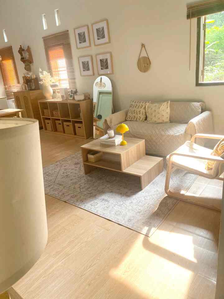 Bright beige and wood-toned living room featuring a cream sofa and minimalist wooden coffee table with a cozy, warm atmosphere