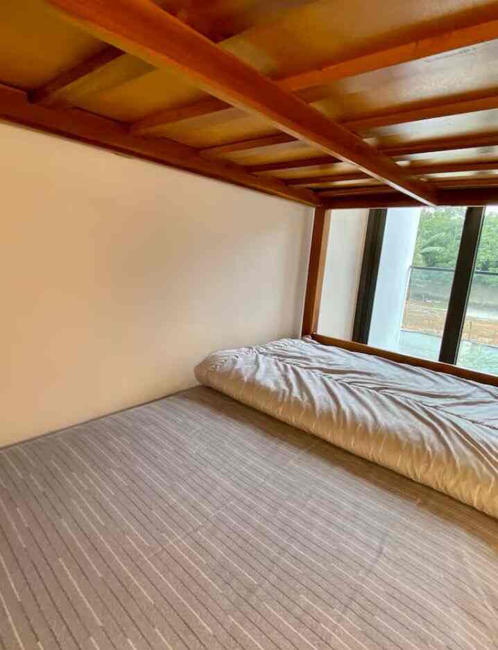 Wood tone bedroom with monotone duvet cover, cozy space with natural light coming through large window
