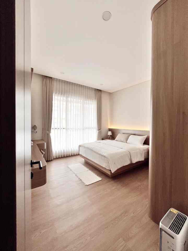 Beige and white toned bedroom with wood flooring and natural modern furniture, creating a comfortable atmosphere