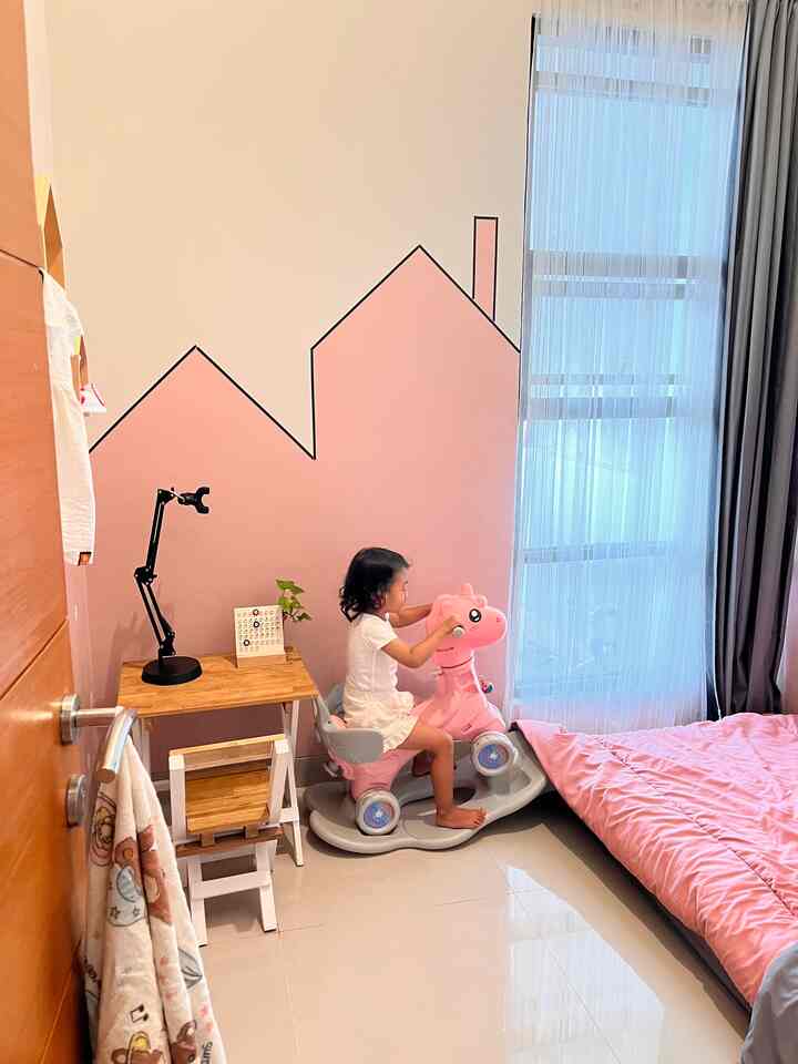 Pink-toned kids' bedroom featuring natural wood furniture with a bright and cozy atmosphere
