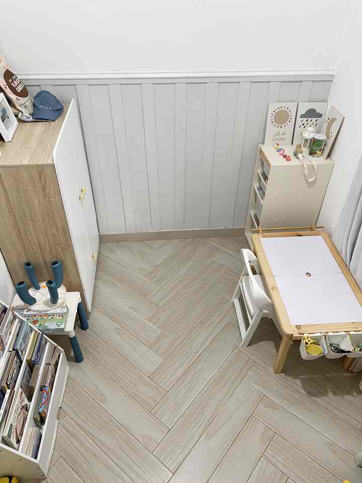 Beige and white toned kids' room featuring a children's desk and storage units with clean, organized atmosphere