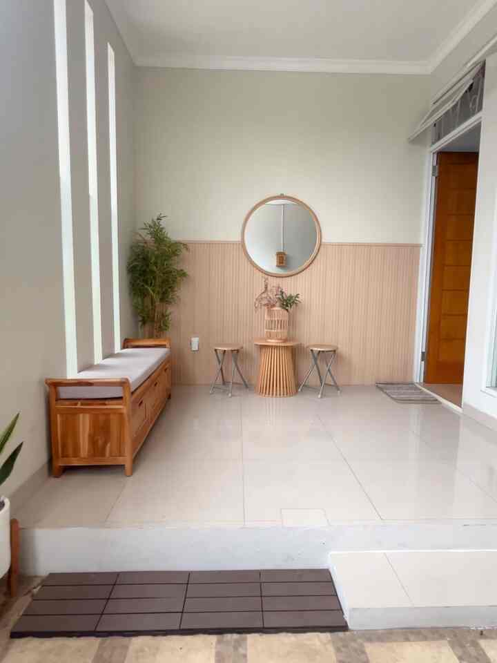 Beige and white toned entrance space featuring wooden bench, side table, and plants with a natural atmosphere