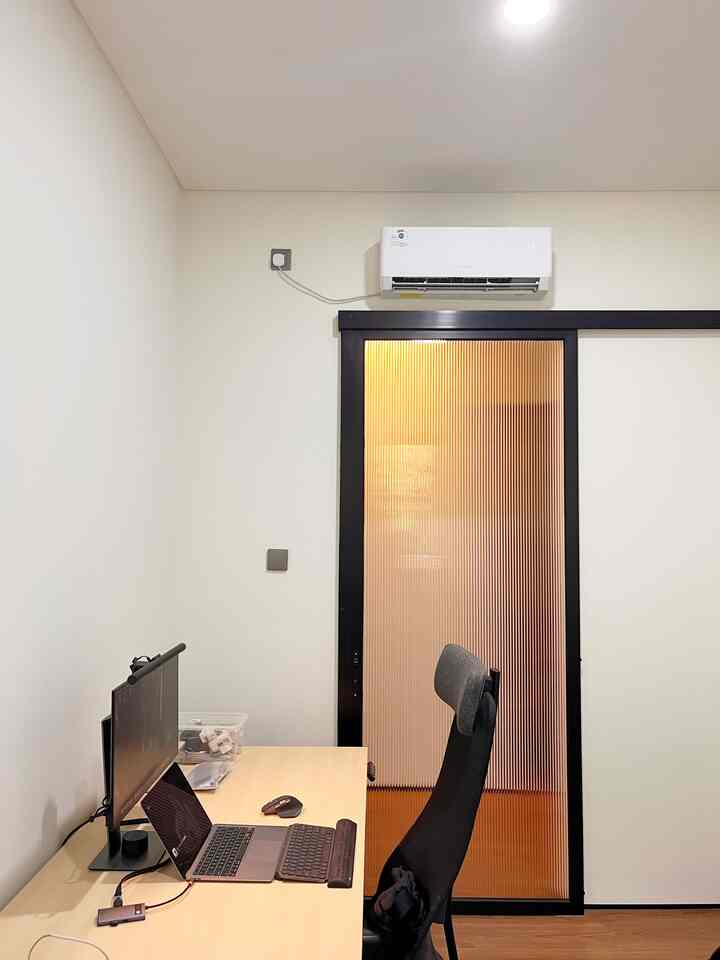Beige desk and black office chair in a simple, modern home office space