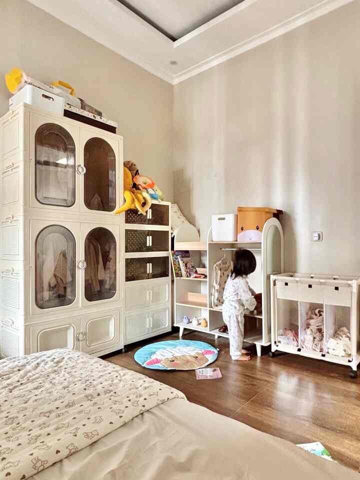 Natural tones and white furniture in a kids' room featuring a bed and multifunctional storage units creating a warm atmosphere