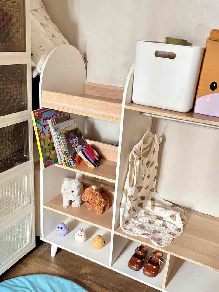 White and wood tone kids' room storage unit featuring organized toys and books with a clean atmosphere