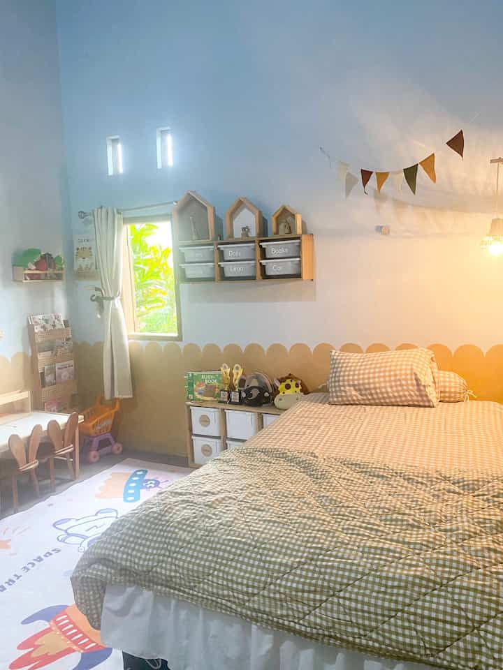 A white and beige toned kids' room featuring a bed and toy storage, designed as a child-friendly space