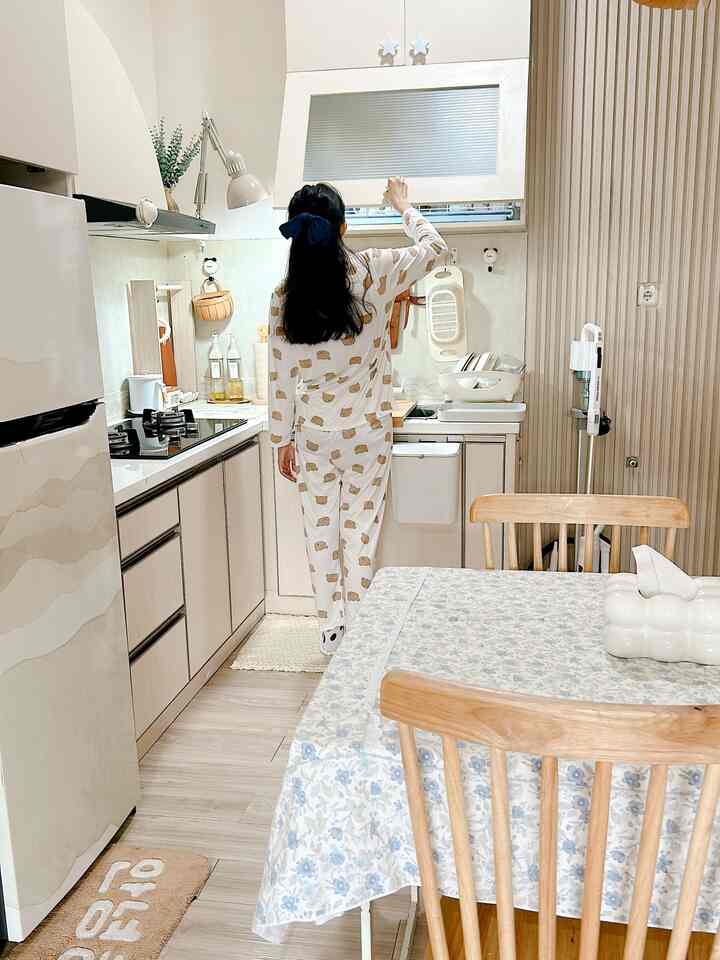 Small kitchen space with white cabinetry and wood tone dining table, creating a cozy kitchen interior