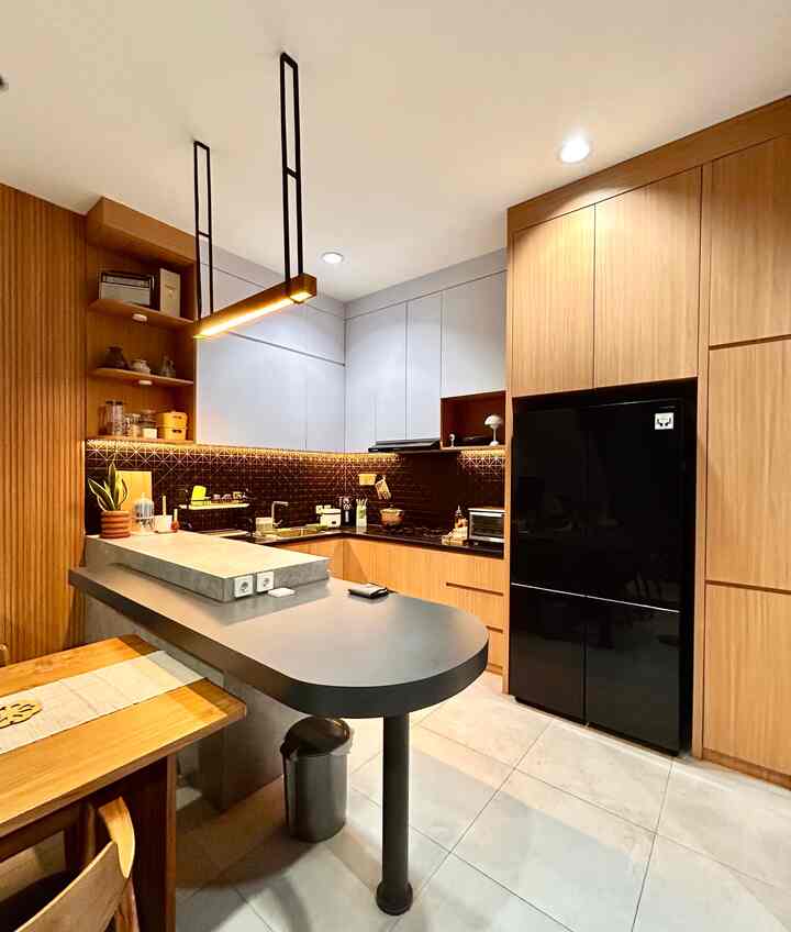 Dapur ini berukuran 2,3x 3,6 m yang bersebelahan langsung dengan meja makan. Karena berukuran sedang, kami desain sedemikian rupa dengan area kompor dan sink bentuk L dan tambahan peninsula untuk tempat persiapan bahan-bahan dan baking.

Karena kami baru sekitar 2 tahun menempati rumah ini storage masih kosong sebagian, tapi belajar dari rumah orangtua sebelumnya kami maksimalkan space sedemikian rupa agar tidak banyak barang terdisplay di area luar sehingga lebih kelihatan rapi.

Ada area untuk penyimpanan bumbu, gula, tepung, beras dan snack di sisi kanan kulkas. Di sisi kirinya terdapat laci-laci untuk sendok, garpu, sumpit, dan peralatan makan lainnya.

Stok tissue, sabun, dan tempat peralatan memasak, juicer, dan lainnya di bawah peninsula. Kami juga masih menyimpan kardus beserta kartu garansi di dalamnya.
Rak piring basah di sebelah sink, dan tempat piring, mangkok, dan gelas dibagian atasnya.

Di sudut kiri kami buat rak untuk tempat obat, p3k, dan toples sereal, beras, dan snack yang mudah dijangkau. Agar tidak membosankan kami letakkan beberapa item dekorasi ✨

#KitchenSet #DapurMinimalis #MejaDapur  #japandi #midcentury #midcenturymodern #DesainDapur #IdeStorage #LampuGantung #KitchenOrganization #DapurRapi #PenyimpananDapur