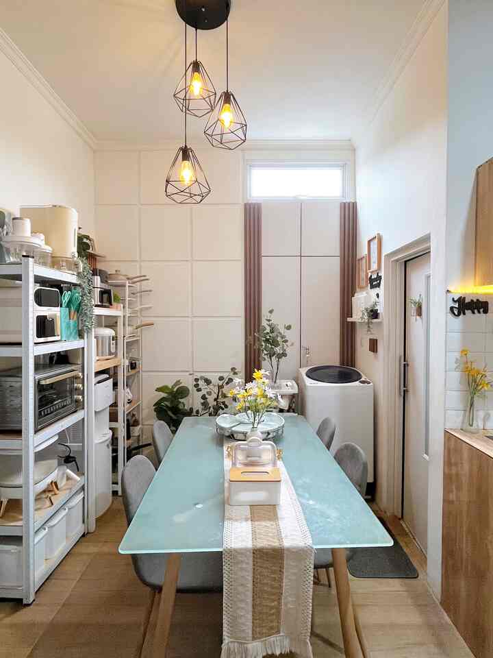 Bright white and natural tone dining room featuring glass table with gray chairs and a textured table runner, creating a clean atmosphere
