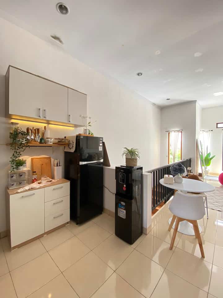 Bright modern kitchen and adjoining living room with white, black, and wood tones blending harmoniously