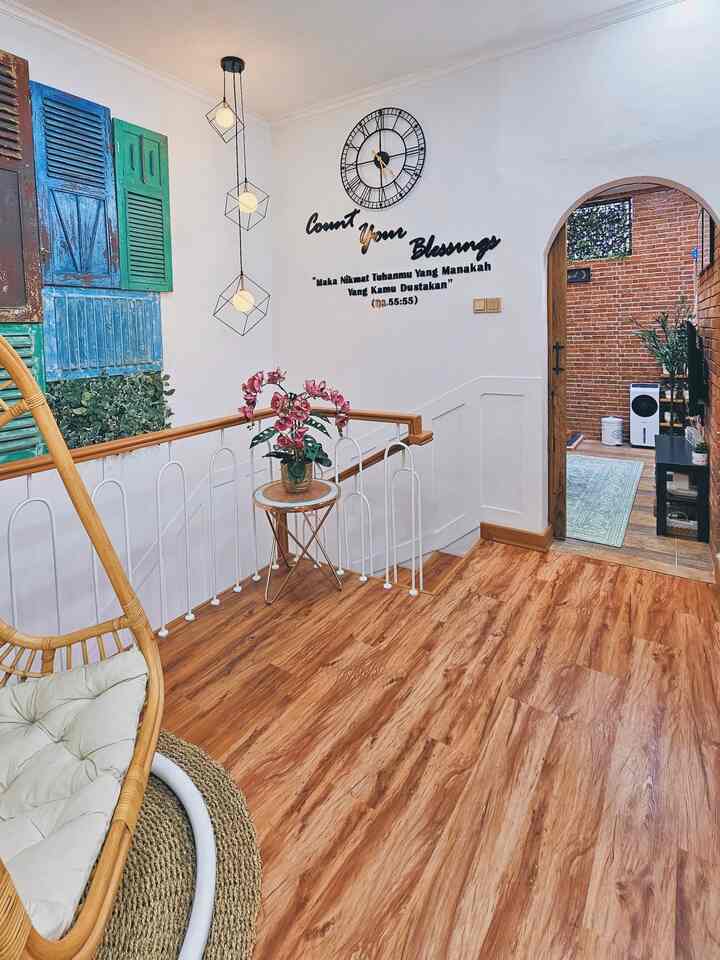 White and brown toned staircase entrance space featuring an arched doorway and plants with a natural interior vibe