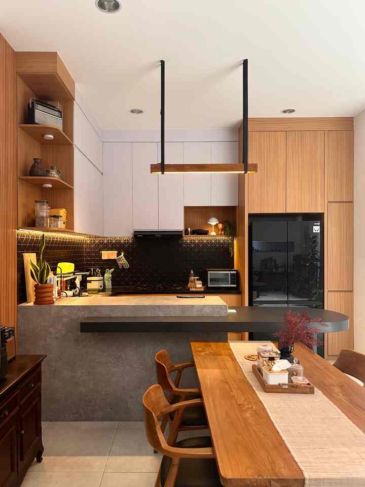 Transformasi kitchen ✨
Karena kami melakukan renovasi total, maka  area kitchen ini juga diisi secara bertahap. Awalnya hanya kosongan saja tanpa dekorasi, namun secara desain kami memang sudah merencanakan rak display untuk beberapa item dekorasi. Keseluruhan material menggunakan finishing HPL, top table granit black gold, dan backsplash tiles.

- Lampu gantung kayu diatas meja island selain fungsional bentuk yang sederhana ini menambah aksen dan karakter pada kitchen.
- Vas bunga dan toples untuk penyimpanan yang mudah dijangkau
- Keset Motif di depan sink, fungsional tapi estetik menambah warna. 
- Lampu Jamur dan pot tanaman sintetik, memberi ambience warm dan tropical.

#Kitchenset #HPL #LampuGantung #backsplashtiles #Toptablegranit #MyDreamKitchen #KitchenRenovation #KitchenStyling #Japandi #Midcentury #DapurModern